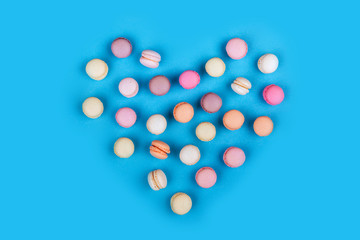 Cake macaron or macaroon on blue background., flavor almond cookies, pastel colors, vintage card. Heart.