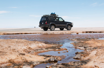 Car near a lake on Uyuni salt flat. Uyuni Bolivia.