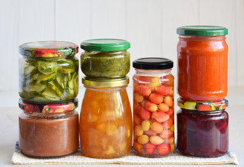 Fototapeta na wymiar Variety of preserved food in glass jars - pickles, jam, marmalade, sauces, ketchup. Preserving vegetables and fruits. Fermented food. Autumn canning. Conservation of harvest