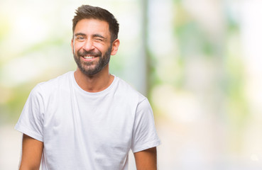 Fototapeta premium Adult hispanic man over isolated background winking looking at the camera with sexy expression, cheerful and happy face.