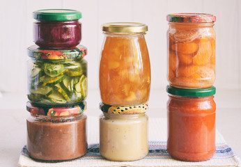 Variety of preserved food in glass jars - pickles, jam, marmalade, sauces, ketchup. Preserving vegetables and fruits. Fermented food. Autumn canning. Conservation of harvest