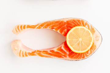 Fresh Sea Red Salmon Fish Steak with slice of lemon isolated on white background. Top view. Flat lay.