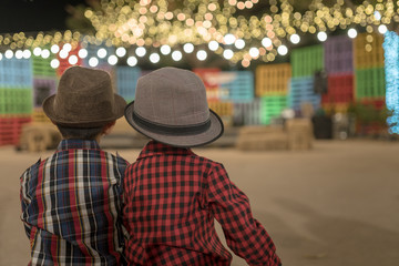 Two boys together sitting in park night event