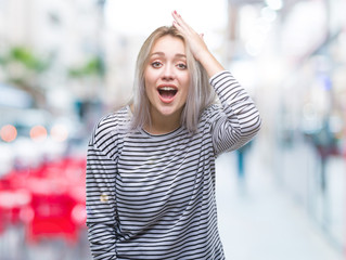 Young blonde woman over isolated background surprised with hand on head for mistake, remember...