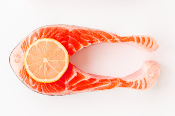 Fresh Sea Salmon Fish Steak trend toned Living coral color with slice of yellow lemon isolated on white background. Top view. Flat lay.
