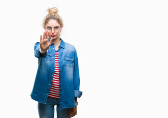 Young beautiful blonde woman wearing glasses over isolated background doing stop sing with palm of the hand. Warning expression with negative and serious gesture on the face.