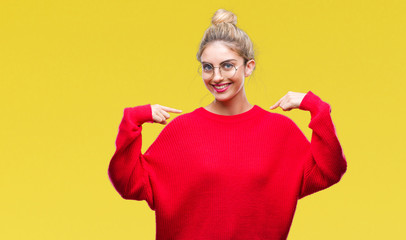 Young beautiful blonde woman wearing red sweater and glasses over isolated background looking...