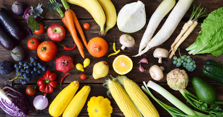 Fruits et légumes blancs, jaunes, verts, orange, rouges, violets sur fond en bois. Nourriture saine. Aliments crus multicolores.