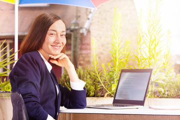 Businesswoman working with laptop at street cafe