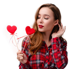 Young beautiful woman with perfect make up and red lips holding hearts on a white background isolated. Lady in checkered shirt. Valentine's Day concept