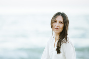 Marine female portrait. Attractive woman in green skirt walks along the shore before the sea while gulls fly over her