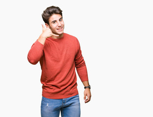 Young handsome man over isolated background smiling doing phone gesture with hand and fingers like talking on the telephone. Communicating concepts.