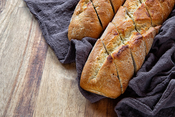 French baguette on wooden background with textiles
