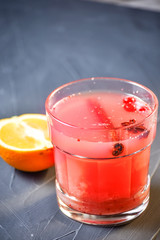 Bar menu hot fruit tea with orange slices, cinnamon and berries on a stone board, copy text background.