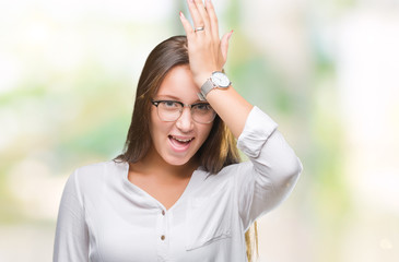 Young caucasian beautiful business woman wearing glasses over isolated background surprised with...