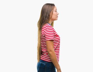 Young caucasian beautiful woman over isolated background looking to side, relax profile pose with natural face with confident smile.