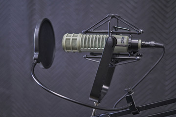 Podcast microphone in recording booth with windscreen