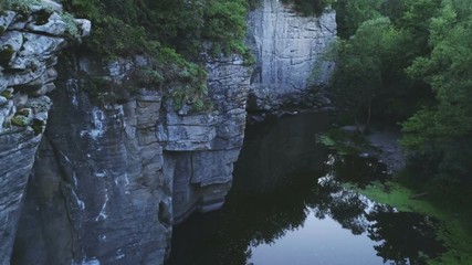 Mountain pond at high split rocks with trees in the Carpathians in summer