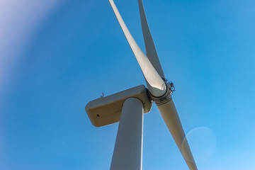 Contre-plongée d'une éolienne sur fond de ciel bleu
