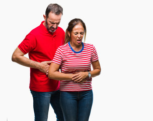 Fototapeta premium Middle age hispanic couple in love over isolated background with hand on stomach because indigestion, painful illness feeling unwell. Ache concept.