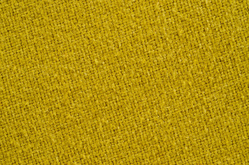 Texture of thick, strong mustard color fabric shot close-up.