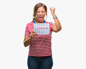 Middle age senior hispanic woman holding menstruation calendar over isolated background annoyed and frustrated shouting with anger, crazy and yelling with raised hand, anger concept