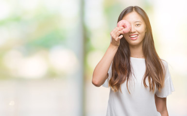 Young asian woman eating donut over isolated background with a happy face standing and smiling with a confident smile showing teeth