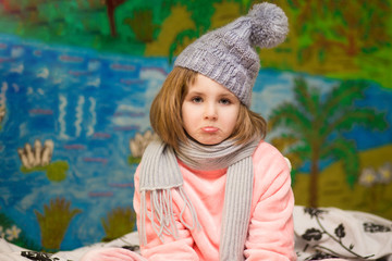 Portrait of sick little girl wear scarves with sad face