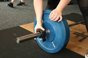 Weightlifter puts a weight on the barbell