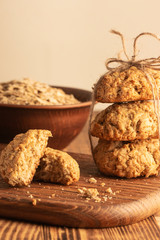 Homemade oatmeal cookies on wooden board on old table background