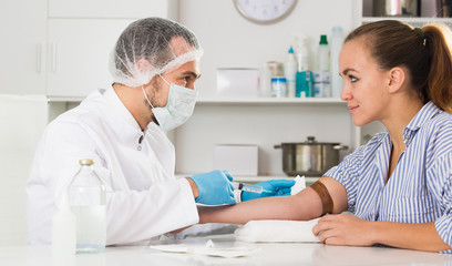 Male nurse injecting female patient