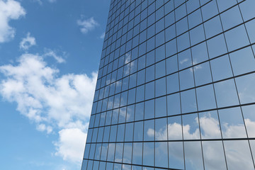 Fototapeta na wymiar Wall of skyscraper under blue sky with clouds