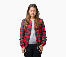 Young beautiful brunette woman wearing a jacket over isolated background skeptic and nervous, frowning upset because of problem. Negative person.