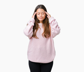 Obraz na płótnie Canvas Young beautiful brunette woman wearing pink winter sweater over isolated background with hand on head for pain in head because stress. Suffering migraine.