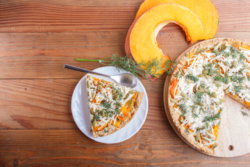 sweet pumpkin pie with cheese and dill on brown wooden background.