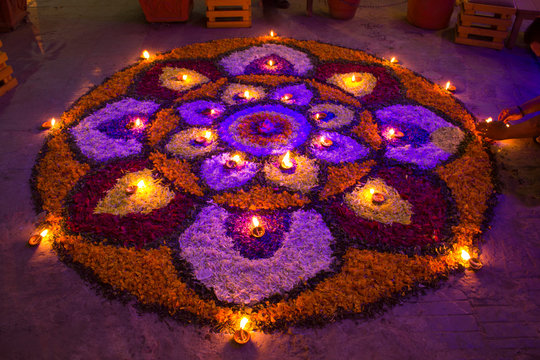 Mandala of flowers with burning candles at night.