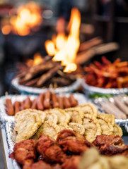 Freshly fried fish, sausages and deep fried chicken feet near the fire on the Nepalese street market