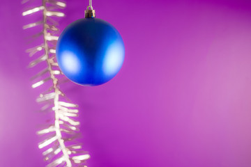Fototapeta premium Blue Christmas ball on a purple background