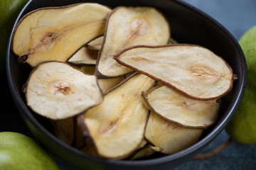 Close-up of pear fruit chips in a bowl, selective focus, studio shot