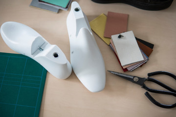 Two white plastic last shoe on rubber secondary cut cutting mat, The equipment used for shoe design.
