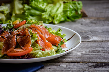 Fresh salad in plate on wooden table
