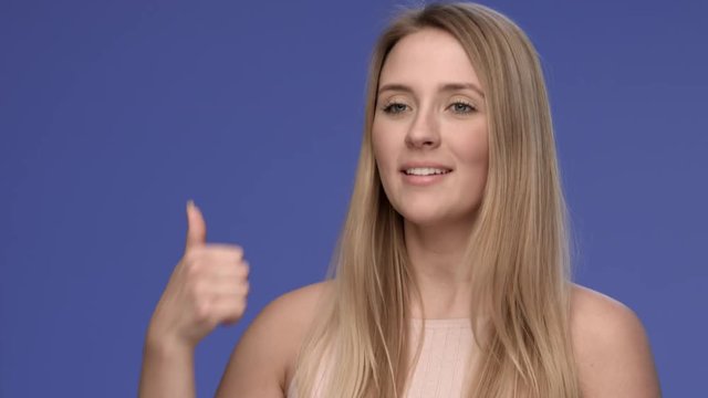 Young and good looking woman showing thumbs up