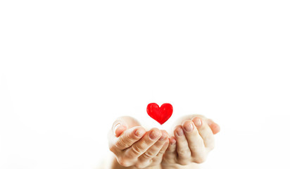 Fototapeta premium Hands of a girl holding a red heart on a white isolated background. lovers day.