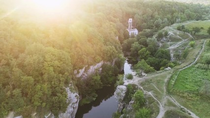 Aerial shot of a twisting river flowing between high rocky banks in summer