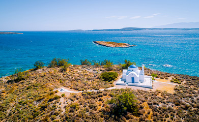 Aerial drone view of small whitewashed orthodox church on the seacoast, Paros Island, Greece