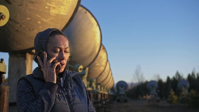 Woman student operator of institute of Solar Terrestrial Physics talking on a cell phone. Unique array solar radio telescope. Sun Solar Radio Telescope. The 'Quasar' observatory in Badary, Russia