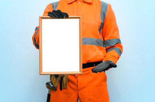 Blank builder certificate. Construction diploma. Contractor is showing a blank photo frame border in his hands. Housing project presentation.