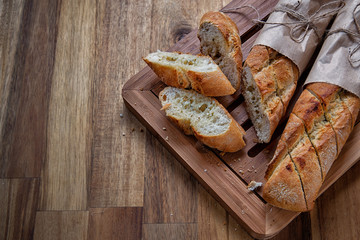Sliced French baguette on wooden background