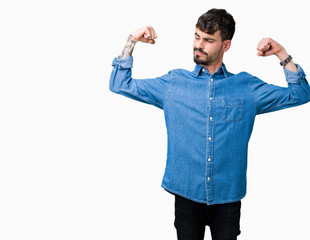 Young handsome man over isolated background showing arms muscles smiling proud. Fitness concept.