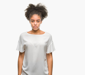 Young afro american woman over isolated background skeptic and nervous, frowning upset because of...
